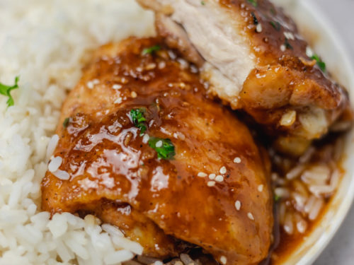 a plate of rice and sticky chicken.