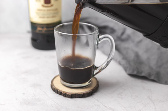 pouring coffee in a glass mug.