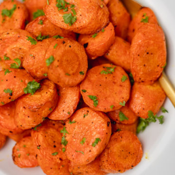 a plate or roasted carrots garnished with chopped parsley.