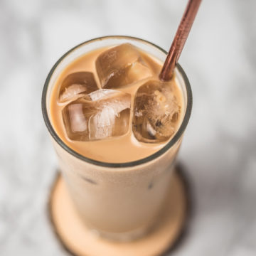 a glass of iced coffee with straw.
