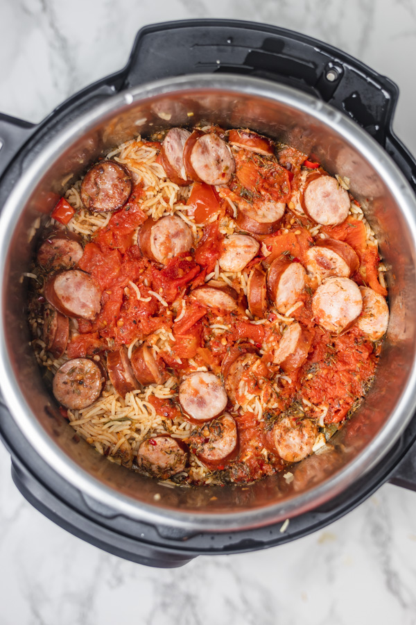 a pot of freshly cooked  instant pot rice with sliced sausages.