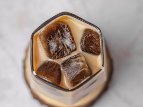 top view of a glass of frozen coffee cubes with milk.