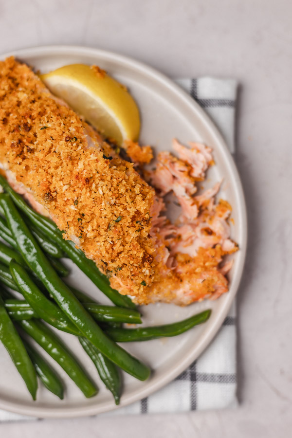 salmon fillet and a side of green beans on a plate.
