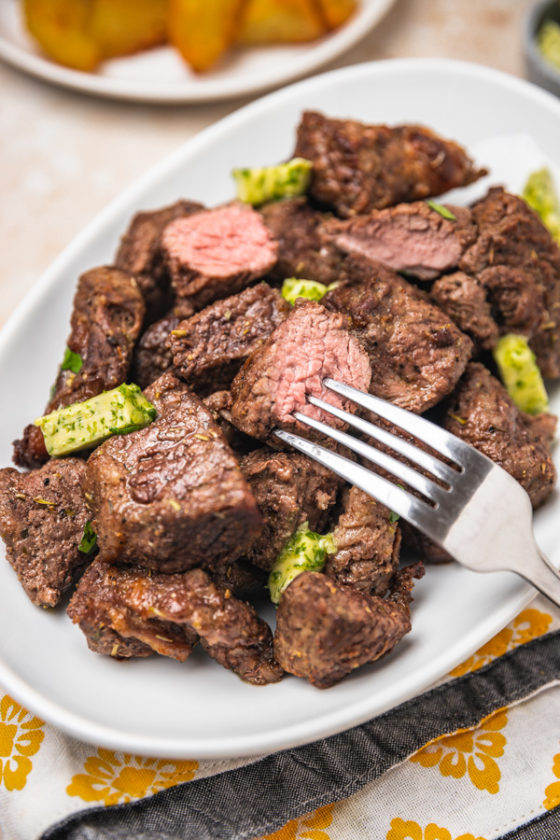 a platter of steak bites with a fork.