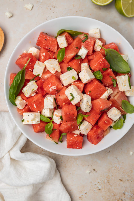 a bowl of fresh watermelon salad with cubed feta cheese and fresh basil.