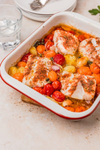 baked cod loin with tomatoes in a baking dish.