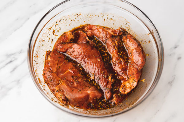 meat marinating in a bowl.