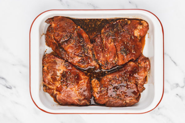 marinated pork in arrainged in a baking sheet.