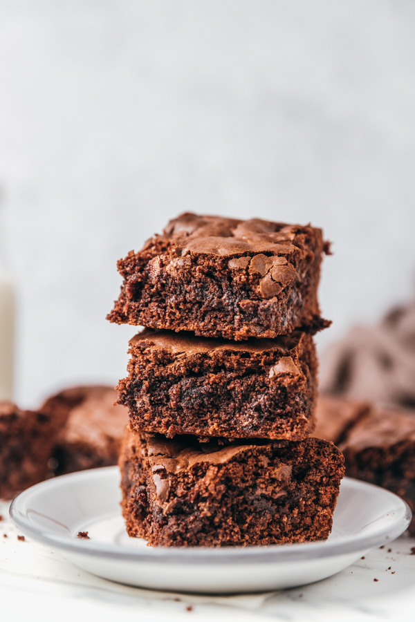 three stacked brownies on a small side plate.