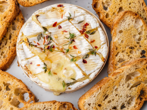 a platter of crostini and baked camembert.