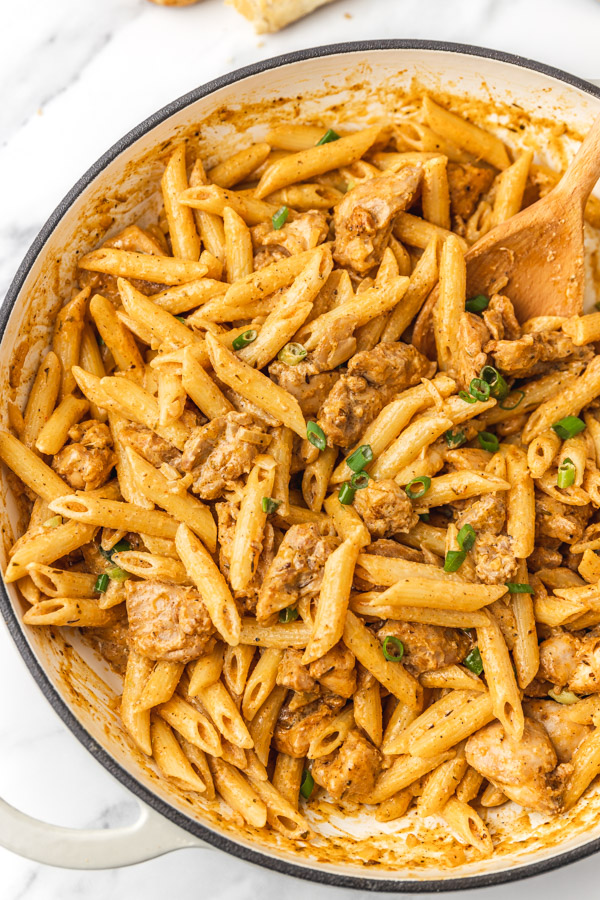 creamy pasta and chicken pieces in a skillet.