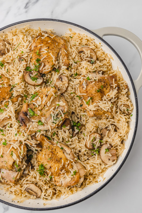 rice, chicken and mushrooms in a skillet.