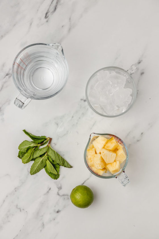 ingredients for pineapple water on a marble surface.