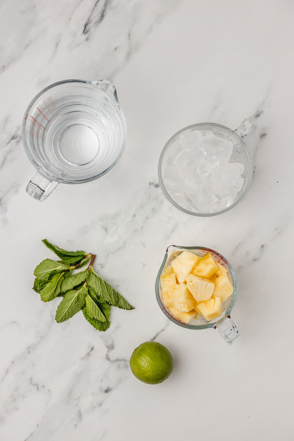 ingredients for pineapple water on a marble surface.