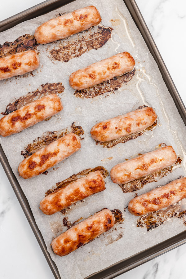 A baking tray of freshly cooked pork sausage.