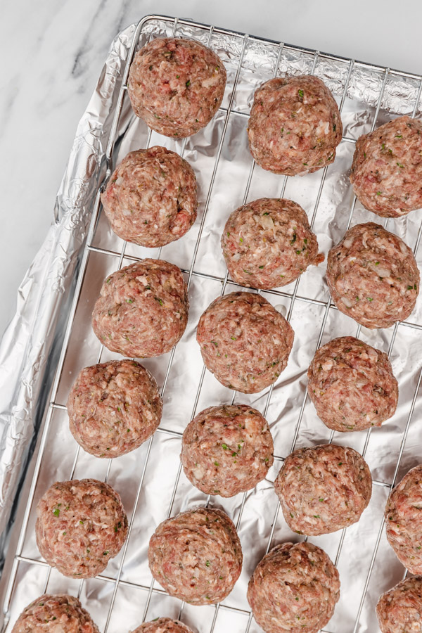 uncooked meatballs on a wirerack.