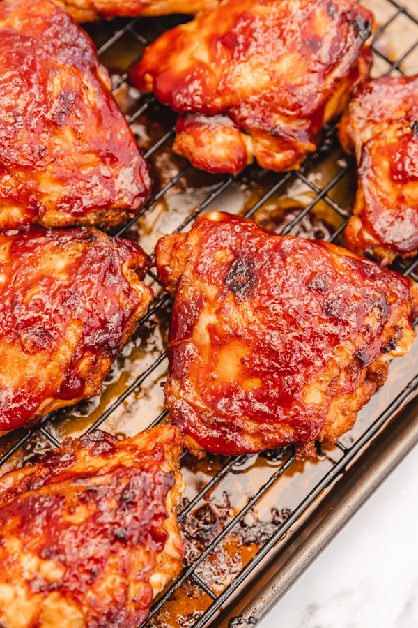 bbq chicken thighs on a baking rack cooling.