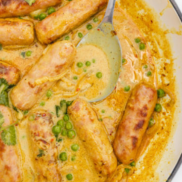 sausage curry in a skillet with green peas.