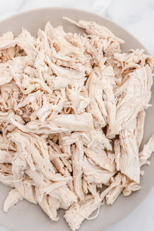 shredded boiled chicken breast on a grey plate.