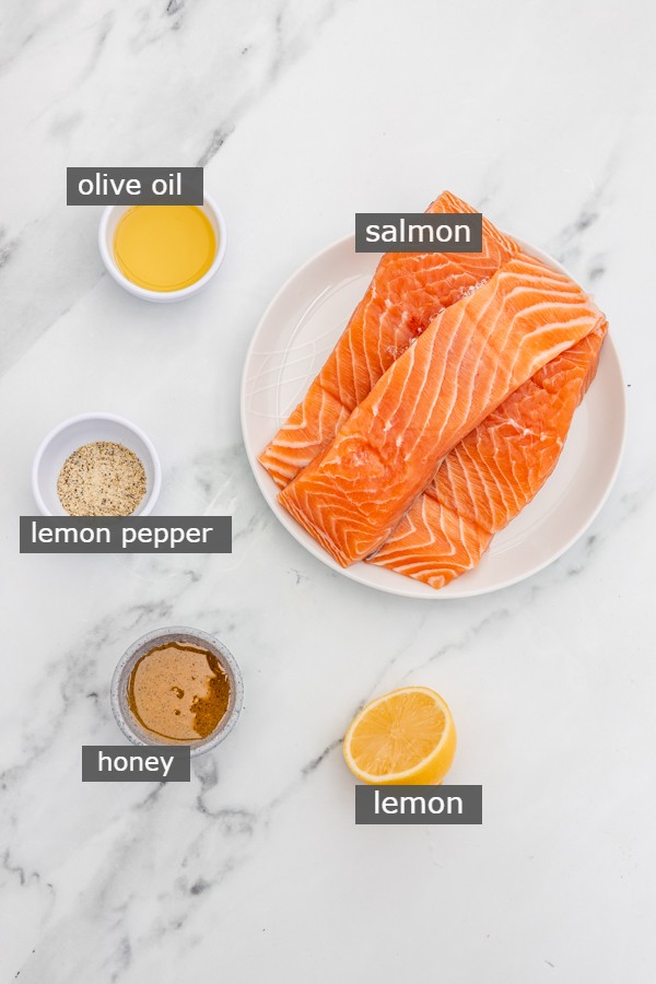 ingredients needed to make broiled salmon on a marble surface.