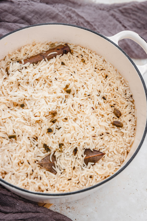 unfluffed cooked jeera rice in a pot.