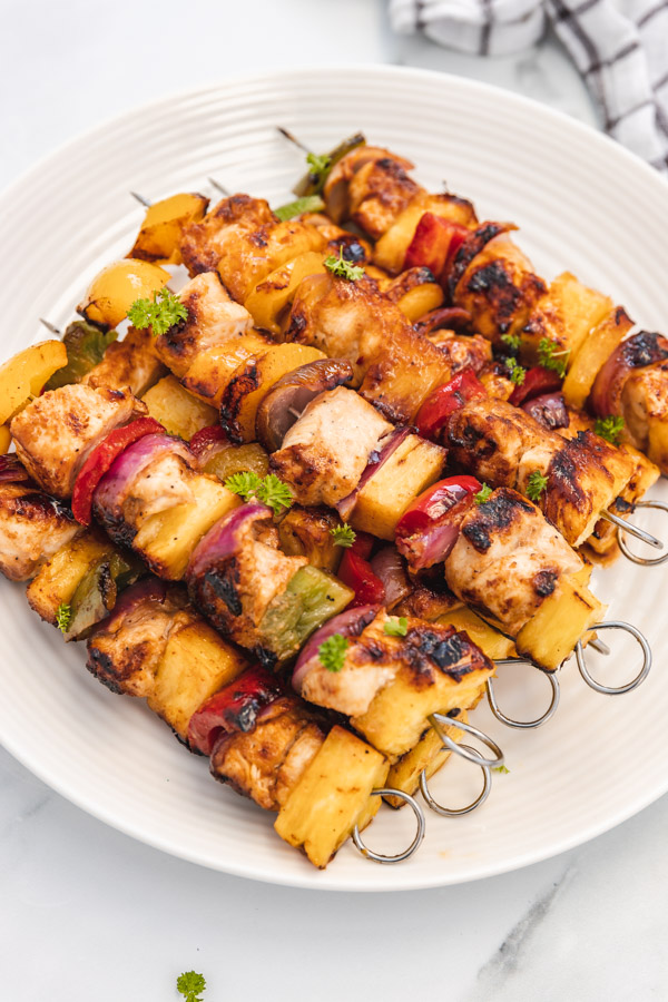 a plate of chicken kabobs stacked over one another.
