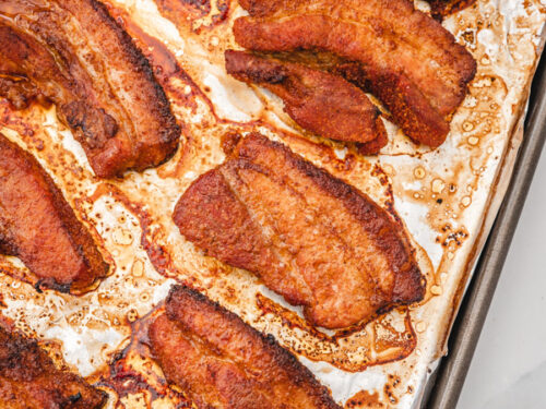 baked pork belly slices on a baking tray.