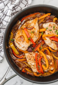 chicken breast and peppers in a skillet.