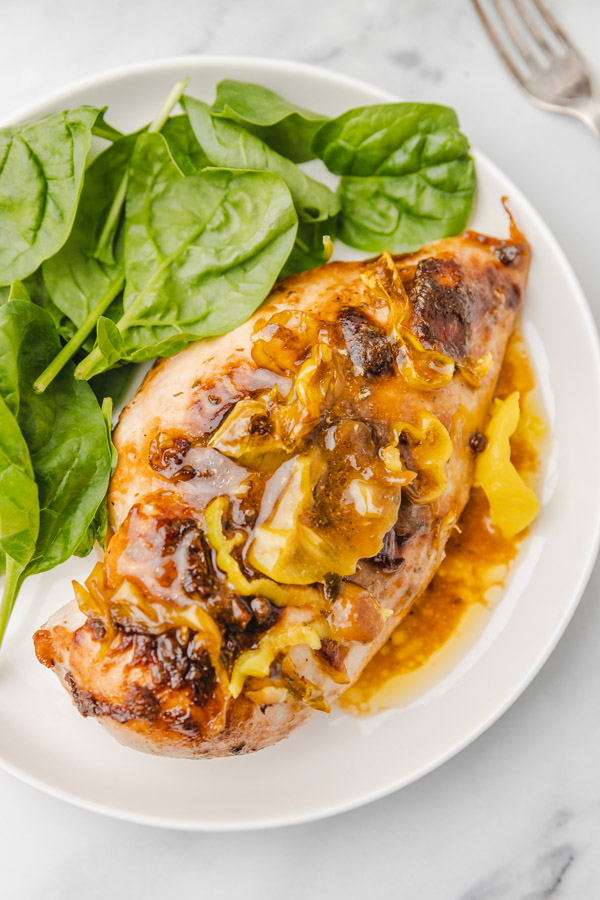 chicken breast served on a plate with spinach.