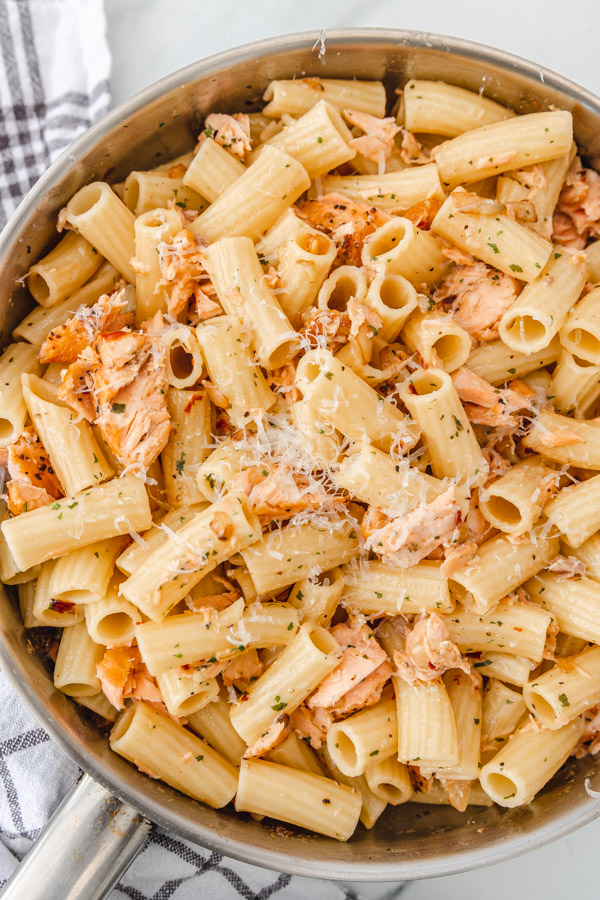a clsoe shot of salmon pasta in a skillet.