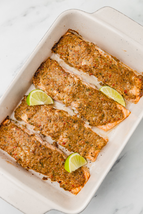 freshly four baked salmon garnised with lime wedges.