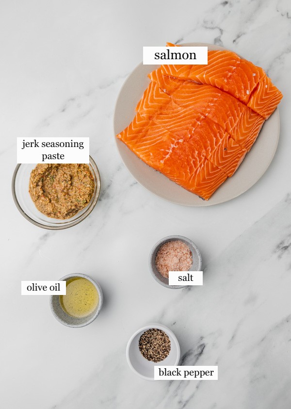 ingredients to make jerk salmon in a white marble surface.