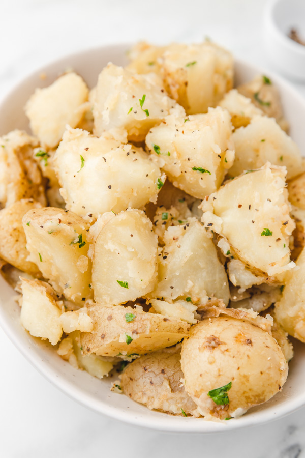 a plate of unpeeled boiled potatoes in a bowl.