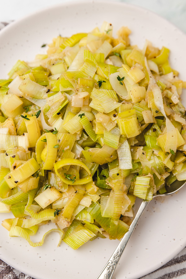 a plate of buttered leeks with a spoon.