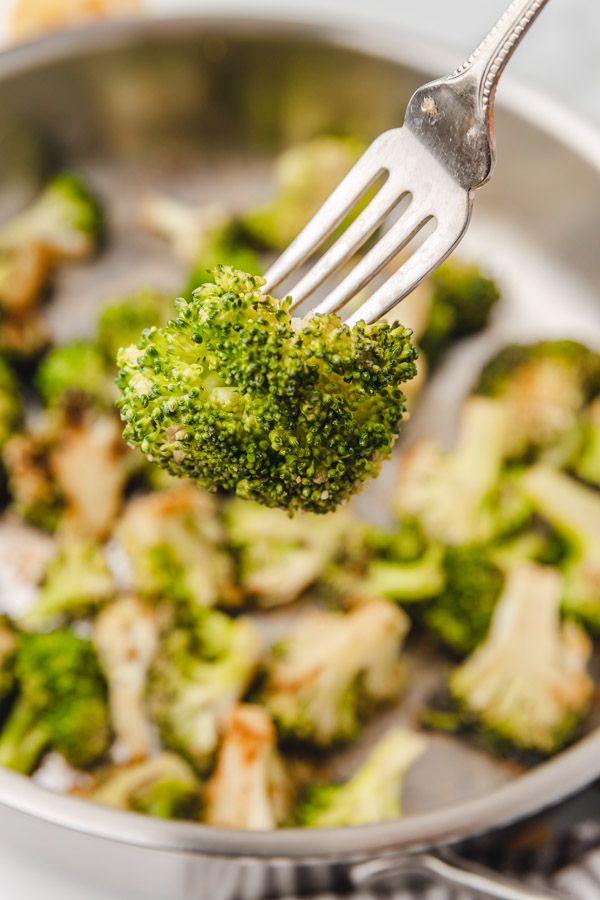 a sauteed broccoli floret on a fork.