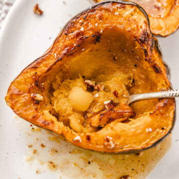a spoon in a cooked acorn squash.