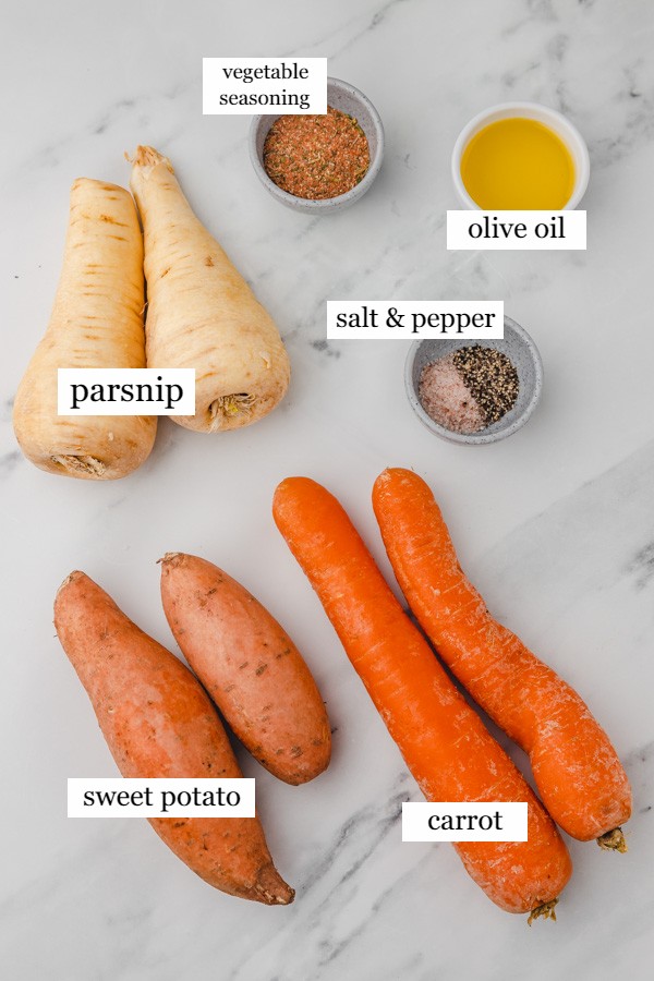 ingredients to make roasted root vegetables on a marble surface.