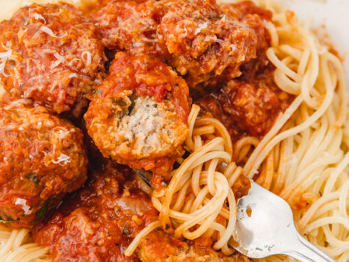 a plate of spaghetti topped with turkey meatballs and tomato sauce.