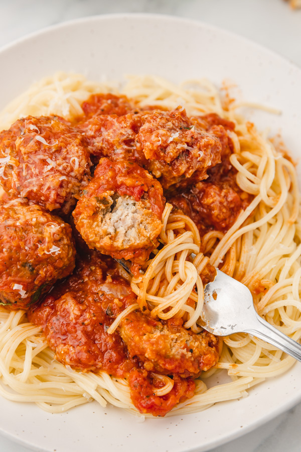 a plate of spaghetti topped with turkey meatballs and tomato sauce.