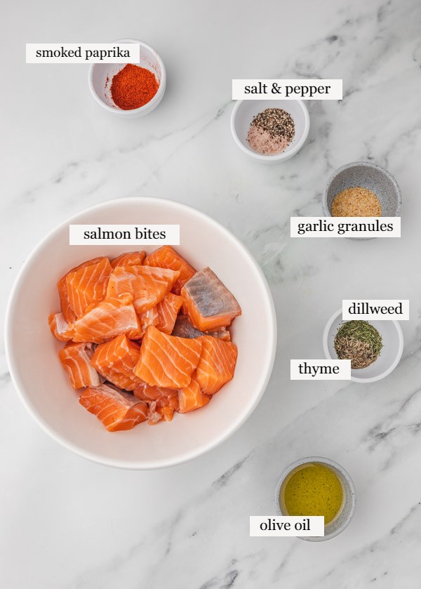 ingredients to make air fryer salmon bites laid out on a marble surface.