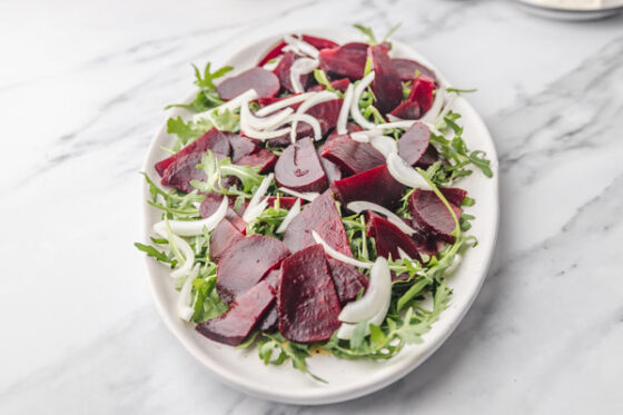 beet, onion and rocket salad on a plate.
