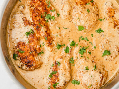 creamy chicken in a skillet placed beside a white napkin.