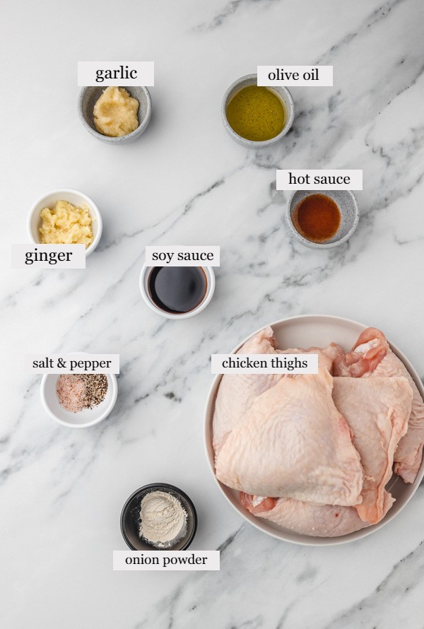 ingredients to make garlic ginger chicken on a marble surface.