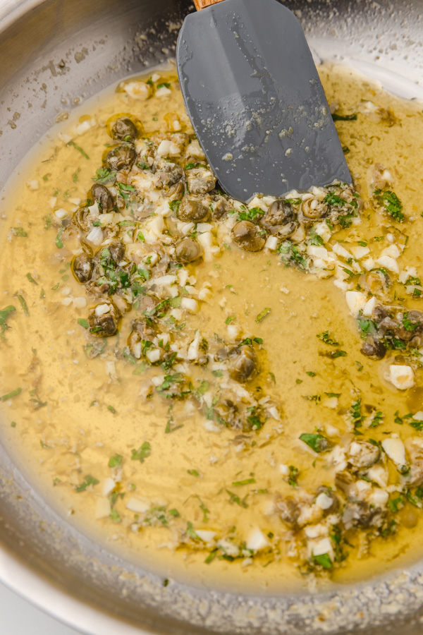 lemon caper sauce in skillet with a spatula.