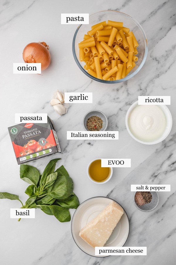 ingrediengts to make tomato ricotta pasta on a marble surface.
