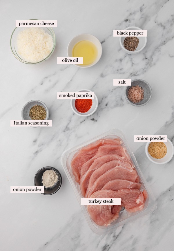 ingredients to cook turkey steaks on a marbles surface.