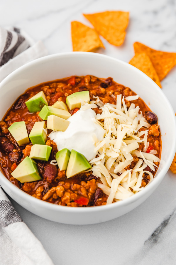 a bowl of turkey chilli served with some tortilla chips.