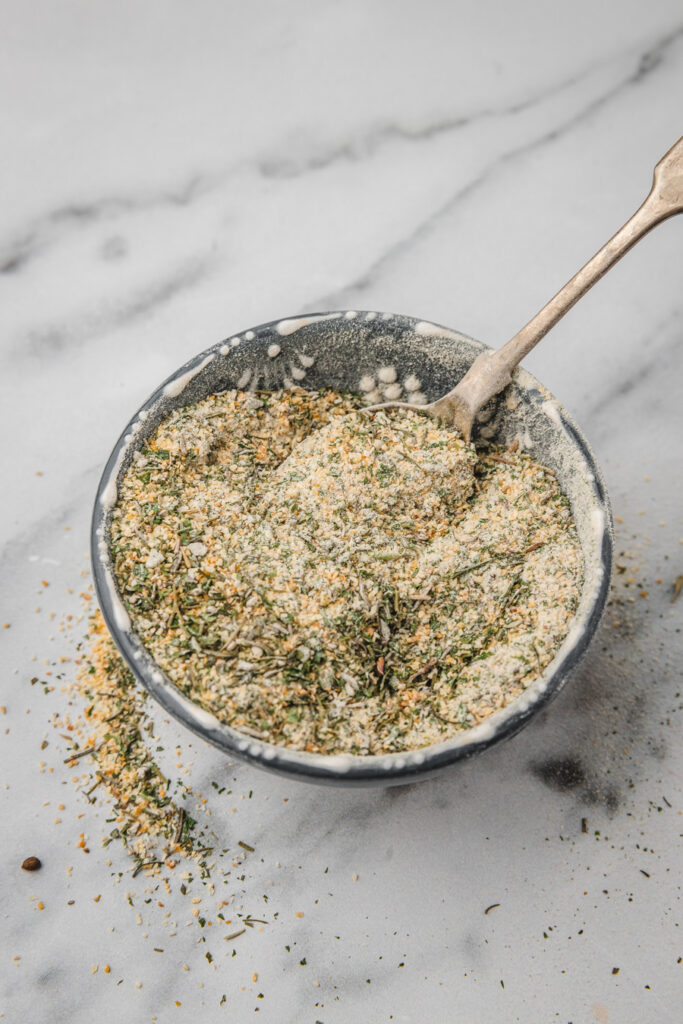 garlic and herb seasoning in a bowl with a spoon.