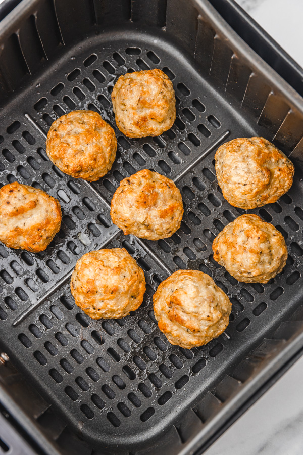 reheated meatballs in air fryer basket.