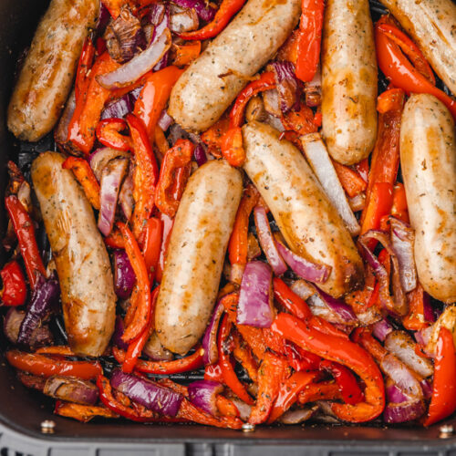 cooked sausage and peppers in air fryer basket.